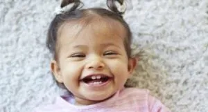 Laughing baby girl lying on a carpet