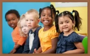 Group of smiling preschool-aged children sitting together