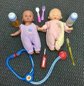 Two baby dolls with bottles, utensils, toothbrush and toy stethoscope