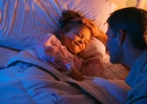 Father talking with his smiling daughter at bedtime
