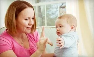 Mother showing a baby a sign during a face-to-face interaction