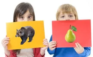 Two children holding up picture cards of a bear and a pear