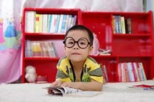 Child in glasses reading with his mouth closed, an example of proper resting posture