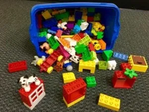 Bin of large Duplo blocks spilled out with animal and figure pieces
