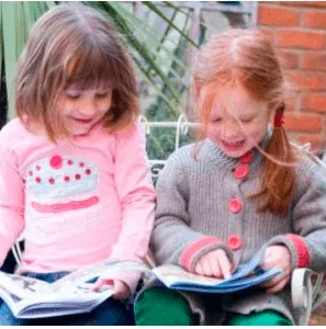 Two young girls reading books side by side