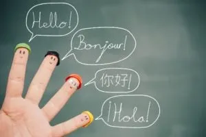 Fingers with drawn faces saying Hello, Bonjour, 你好 and ¡Hola! in speech bubbles